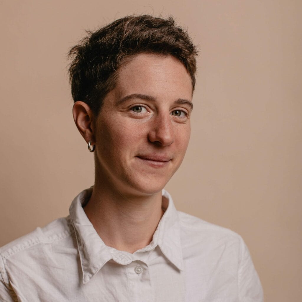 Photo d'une femme souriante en tenue professionnelle, représentant le coaching organisationnel.