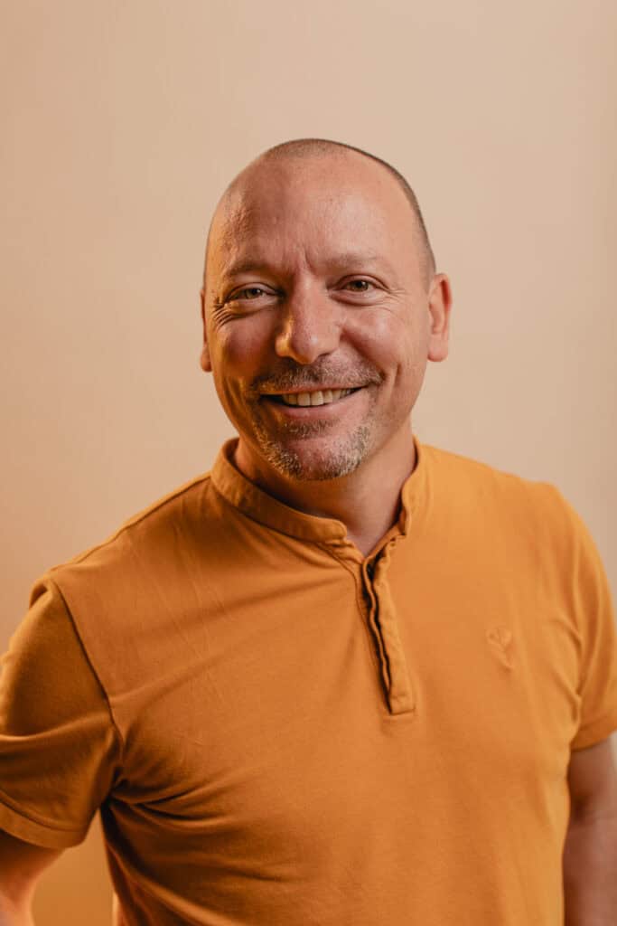 Homme souriant en coaching organisationnel, prêt à accompagner les managers dans leur transformation.