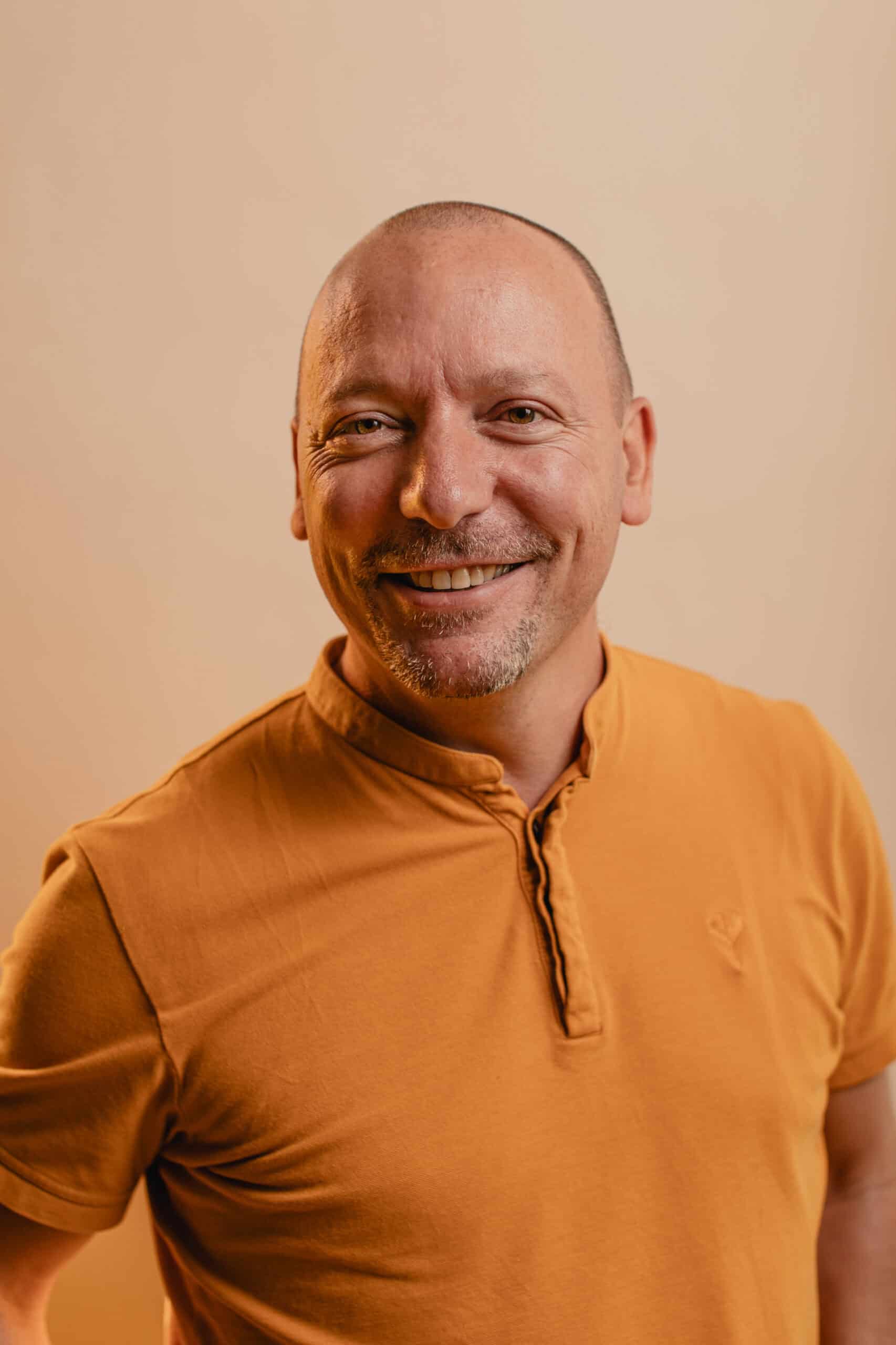 Homme souriant en coaching organisationnel, prêt à accompagner les managers dans leur transformation.