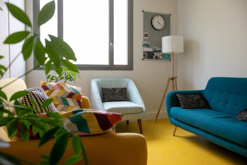 Espace de coaching avec canapés colorés et ambiance chaleureuse pour ateliers et formations.