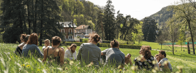 Groupe de personnes en atelier de coaching holacratique dans un environnement naturel.