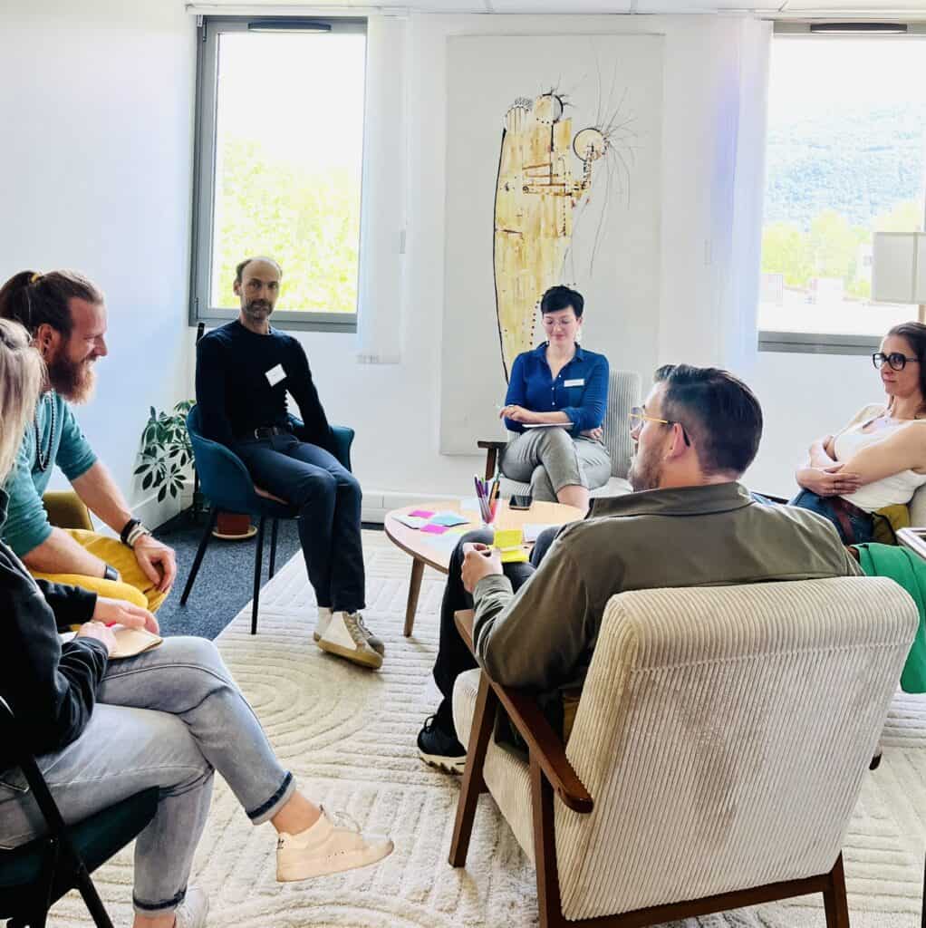 Groupe en atelier de facilitation en salle lumineuse avec tableau blanc.