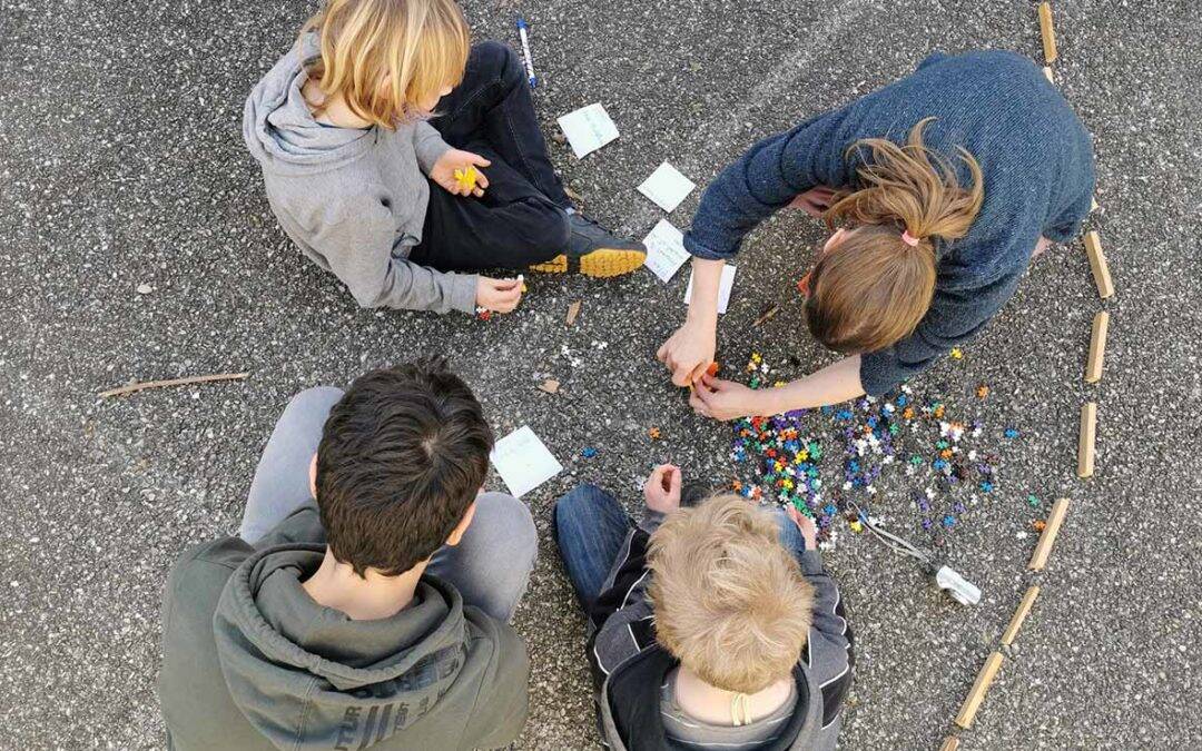 Enfants jouant avec des blocs et des perles dans un espace éducatif créatif.