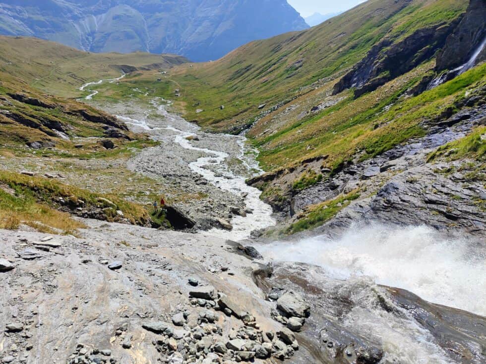 Source d'eau en montagne avec rivière et vallées verdoyantes.