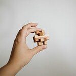 Balancier en bois dans une main, symbolisant la gestion efficace.